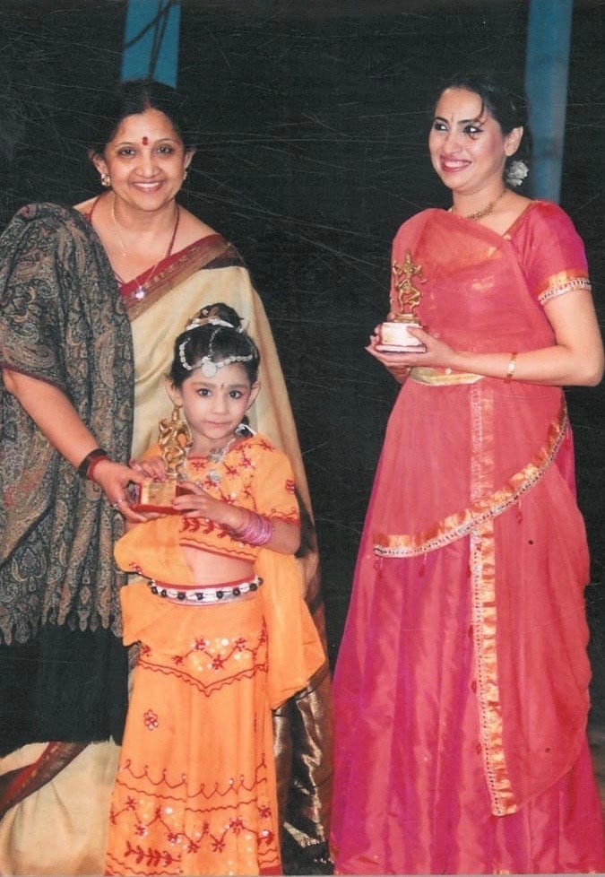 Woman and young girl receiving dance trophies at award ceremony