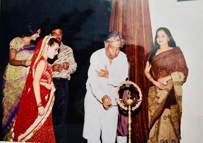 Group lighting ceremonial diya lamp on stage at dance event
