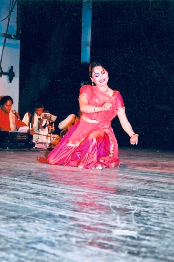 Dancer in pink performing solo on stage with live musicians